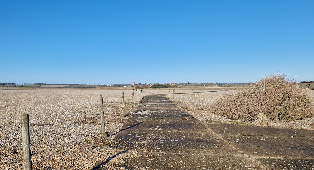 A concrete path cutting through the shingle fields at Orford Ness
